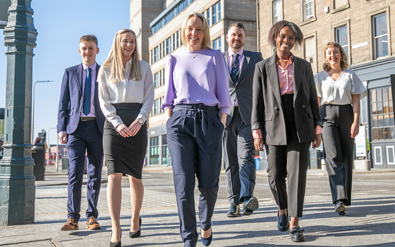 Lesley walks outside the Dundee Thorntons office with the five new Trainees.